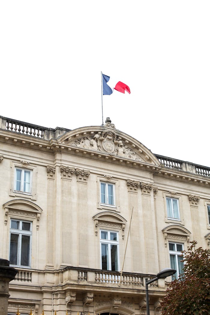 Mastering the First Impression: Your intriguing post title goes here Historic building in France displaying the national flag, showcasing classic European architectural style.